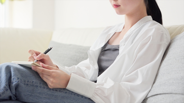 30代で仕事を辞めたいと感じたときに、気持ちや状況をノートに書き出して整理している様子